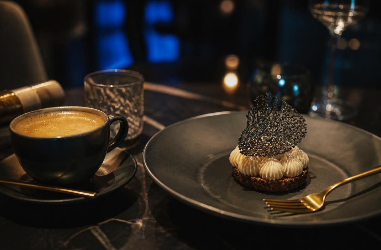 Herhaalbezoek horeca closeup van koffie en dessert op donkere tafel in restaurant bij warm licht