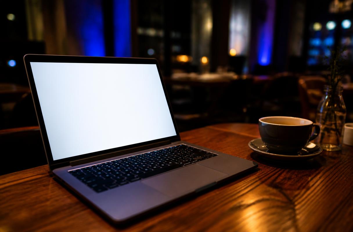 AI jaaroverzicht horeca closeup van laptop en koffie op restauranttafel in de avond