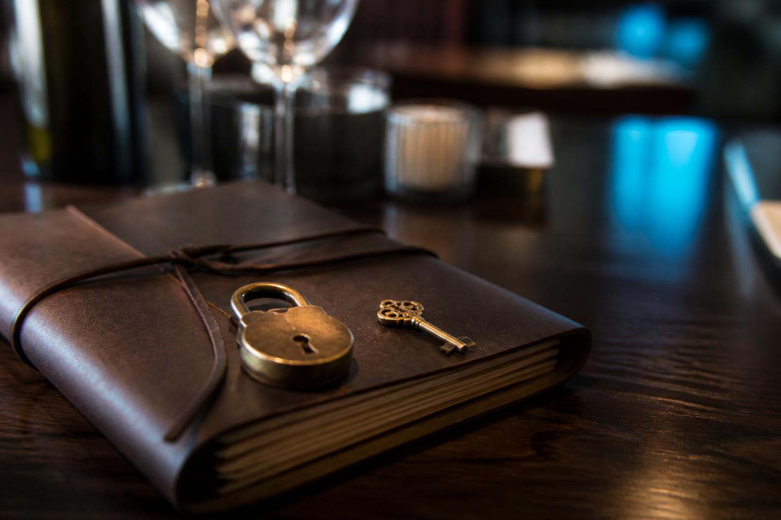 AI klantenservice veilig horeca slot en sleutel naast leren reserveringsboek op donkere walnoot restauranttafel met messing accenten