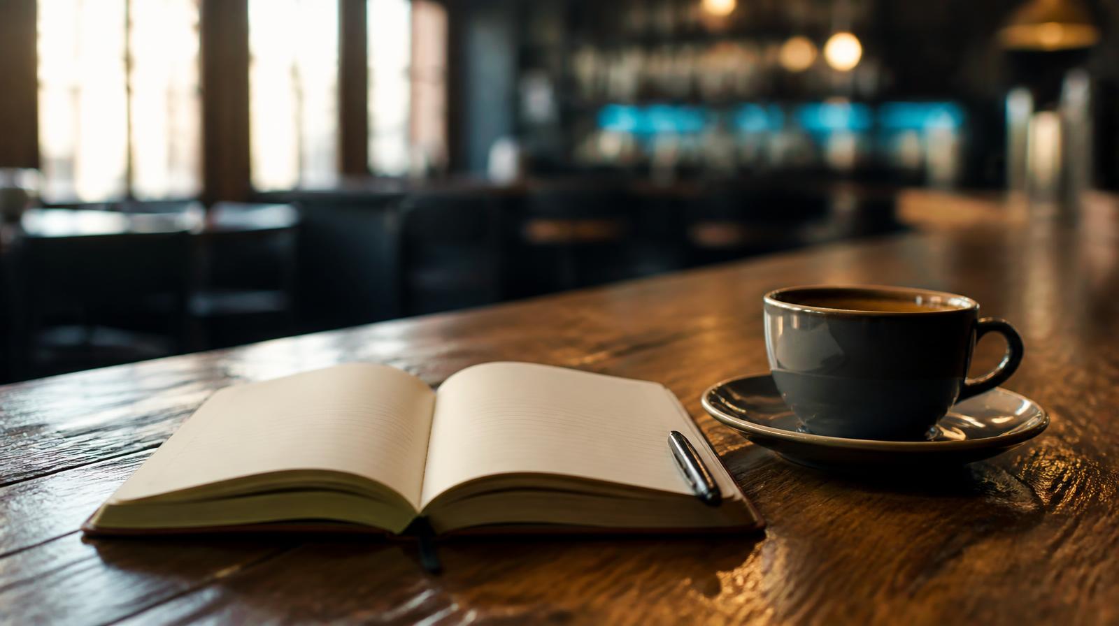 Starten met AI in de horeca closeup van notitieblok met vragen naast een kop koffie op een donkere bar