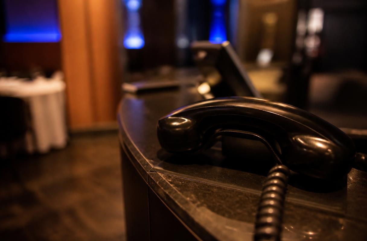 AI horeca beginners closeup van een klassieke telefoonhoorn op een donkere balie